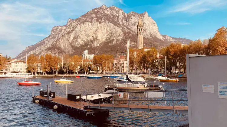 View of Resegone mountain and bell tower from the lakeside promenade in Lecco